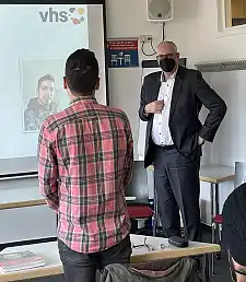 Bürgermeister Andreas Bovenschulte im Gespräch mit einem Deutschkurs-Teilnehmer. Foto vhs Bremen