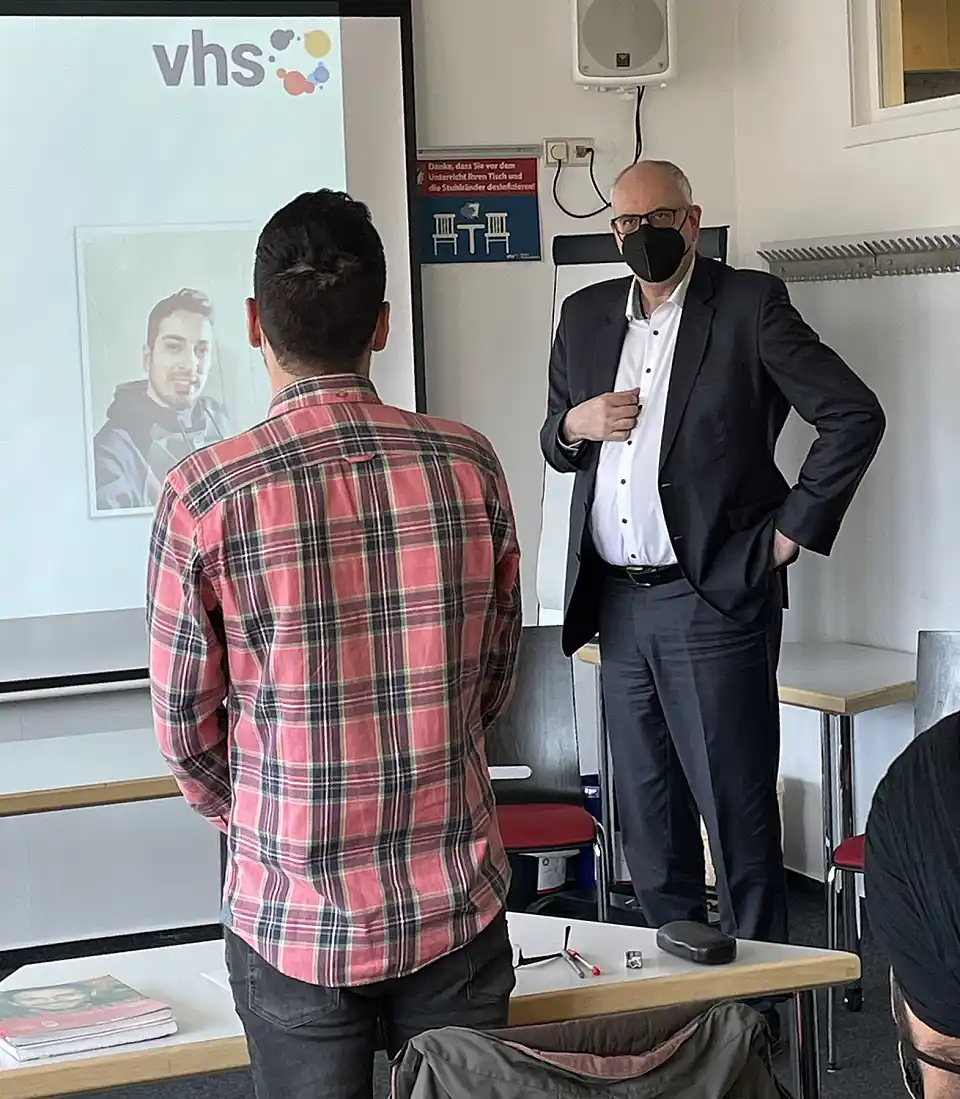 Bürgermeister Andreas Bovenschulte im Gespräch mit einem Deutschkurs-Teilnehmer. Foto vhs Bremen
