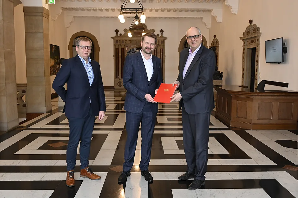 Bürgermeister Andreas Bovenschulte (re.) überreicht dem alten und neuen Ortsamtsleiter Florian Boehlke seine Ernennungsurkunde. Begleitet wurde Boehlke dabei von Beiratssprecher Martin Hornhues. Foto: Senatspressestelle