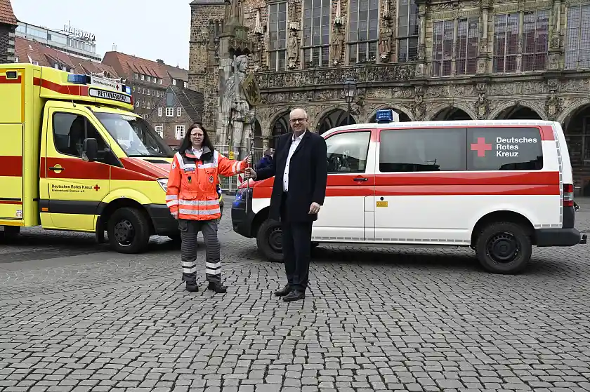 Roswitha Tromp. stellvertretende Landesbereitschaftsleiterin des DRK Oldenburg, übergibt die Fackel an Bürgermeister Andreas Bovenschulte