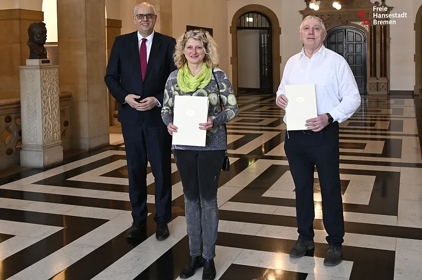 Die neue ehrenamtliche Ortsamtsleiterin in Strom, Cornelia Renken, erhielt von Bürgermeister Dr. Andreas Bovenschulte (links) die Ernennungsurkunde, während der scheidende Ortsamtsleiter Wilfried Frerichs aus dem Amt verabschiedet wurde. Foto: Senatspressestelle