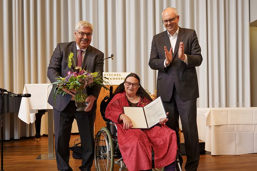 Helene Daiminger mit der vom Bundespräsidenten unterzeichneten Urkunde und den Gratulanten Oberbürgermeister Melf Grantz (links) und Bürgermeister Andreas Bovenschulte (rechts). Foto: Pressestelle des Magistrats/Pheline Hanke