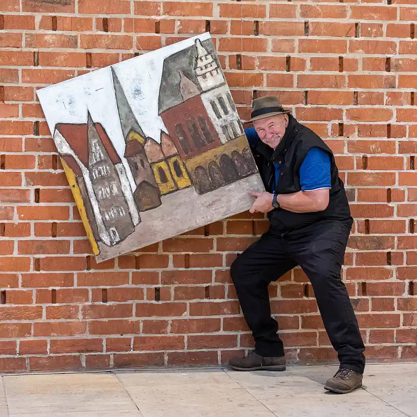 Der Künstler Alexander Dettmar beim Aufbau der Ausstellung Deutschland eine Malerreise – Welterbestätten. Foto: Patric Leo