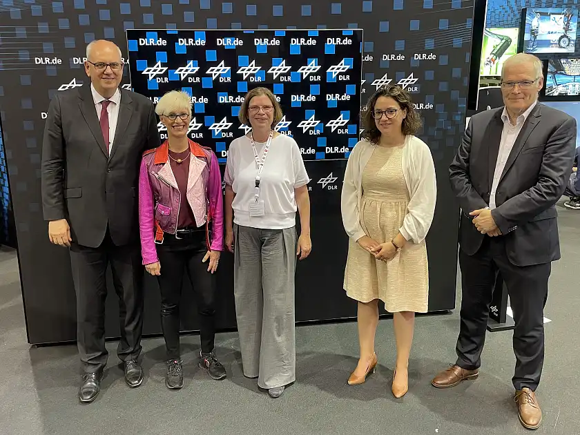 Am Stand des Deutschen Zentrums für Luft- und Raumfahrt auf der ILA Berlin:  (v.l.n.r.) Bürgermeister Dr. Andreas Bovenschulte, Prof. Anke Kaysser-Pyzalla, Senatorin Kristina Vogt, Staatsministerin Sarah Ryglewski und Rolf Henke, Luftfahrtkoordinator bei der Senatorin für Wirtschaft, Arbeit und Europa. Foto: Senatspressestelle