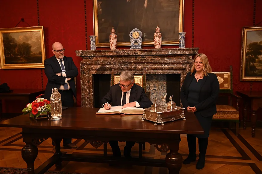 Der EU-Kommissar für Beschäftigung und Soziale Rechte, Nicolas Schmit trägt sich nach gemeinsamen Gesprächen mit Bürgermeisterin Maike Schaefer (rechts) und Staatsrat für Wirtschaft, Arbeit und Europa, Kai Stührenberg (links) in das Goldene Buch ein. Foto: Senatspressestelle 