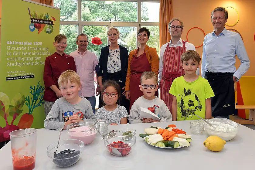Die Kinder und das Team um Küchenleiterin Olga Neubauer (1.v.l.) und Kitaleiter Christoph Anders (2.v.l.) begrüßten Umweltstaatsrat Enno Eike Nottelmann (5.v.l.), KiTa Bremen Geschäftsführer Wolfgang Bahlmann (6.v.l.) , Mücella Demir von BioStadt Bremen (4.v.l.) und Wiebke von Atens-Kahlenberg vom BIPS (3.v.l.). Foto: Pressereferat SKUMS