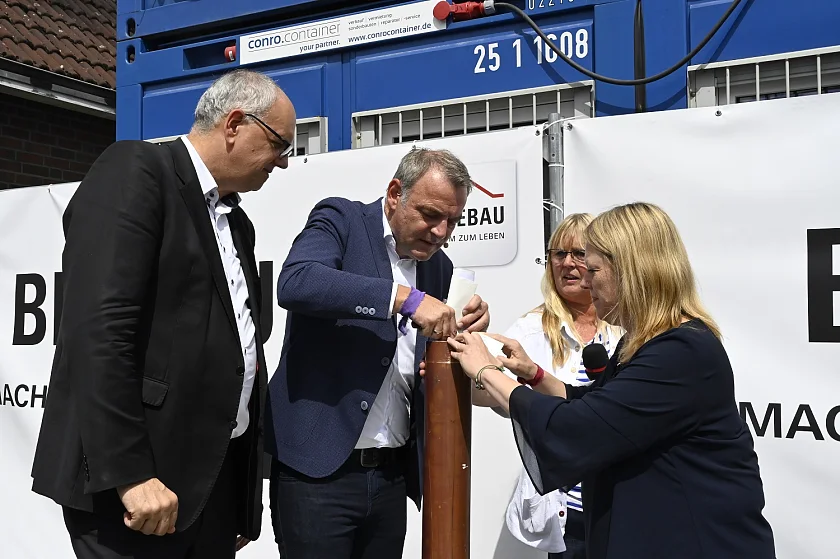 Bürgermeister Andreas Bovenschulte und Bausenatorin Schaefer stecken gemeinsam mit BREBAU-Geschäftsführer Bernd Botzenhardt und Schulleitern Ruth Raue die Wünsche der Kinder für die Schule in die Zeitkapsel. Foto: Senatspressestelle
