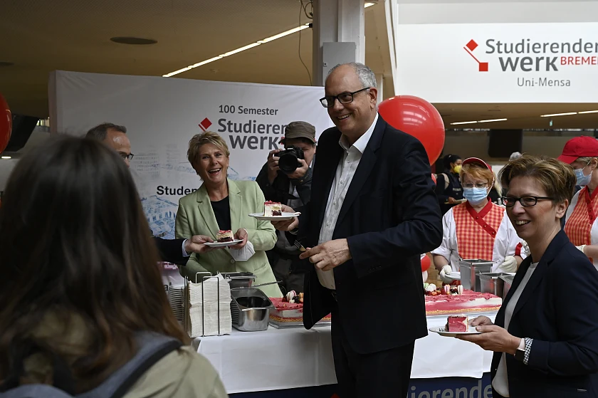 Torte für die Studierenden: Bürgermeister Andreas Bovenschulte und Wissenschaftssenatorin Claudia Schilling verteilen Kuchenstücke in der Mensa. Foto: Senatspressestelle