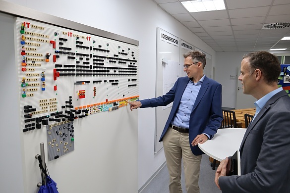 Finanzstaatsrat Martin Hagen (links) zeigt Staatssekretär Dr. Markus Richter (rechts) den Dienstplan aus Legosteinen. Foto: Finanzressort 