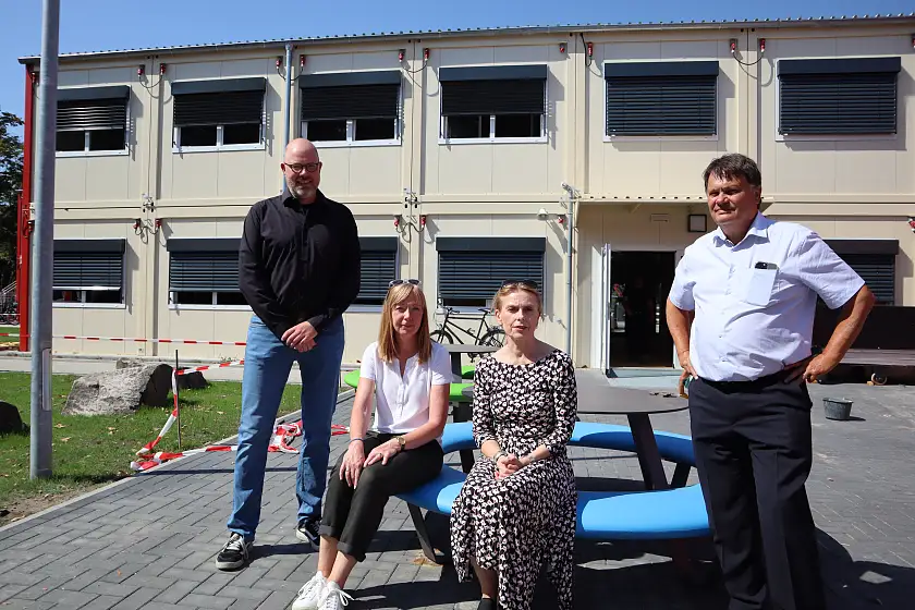 Der Mobilbau am Jakobsberg ist für die nächsten Jahre des Neubaus der Standort der Schule Alter Postweg. Hier im Outdoor-Klassenzimmer (VL): Schulleiter Sebastian Gerber, Projektleiterin bei Immobilien Bremen Christiane Berding, Geschäftsführerin Immobilien Bremen Susanne Kirchmann, Finanzsenator Dietmar Strehl. Foto: Finanzressort 