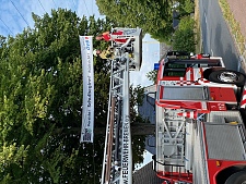 Mit Unterstützung der Feuerwehr brachte Bildungssenatorin Sascha Karolin Aulepp das erste Banner in luftiger Höhe an. Foto: Bildungsressort