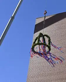 Der Kranz fliegt: Der Schmuck für das Dach signalisiert, dass die Projekte dort jetzt auf der Zielgeraden sind. Foto: Senatspressestelle