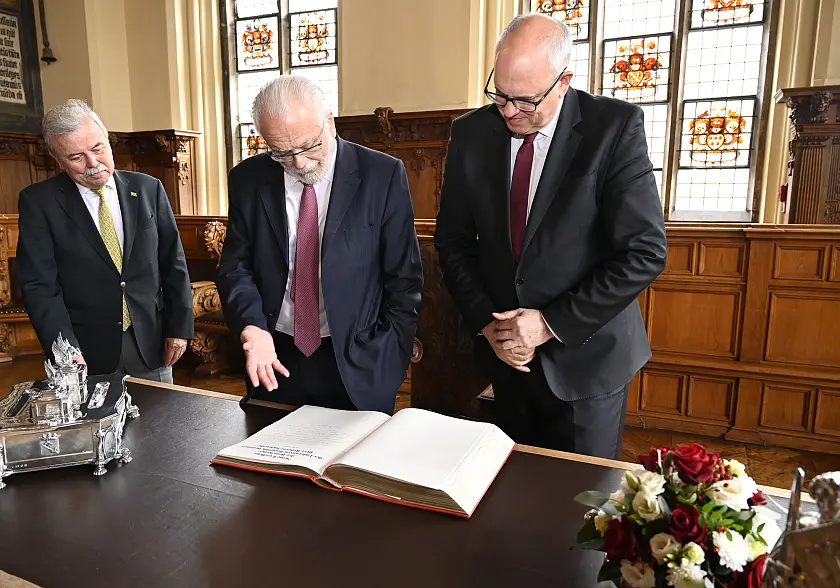 Der brasilianische Botschafter Roberto Jaguaribe (2. vl.), Bürgermeister Andreas Bovenschulte (r.) und Bremens Honorarkonsul Haro Helms (l.) schauen sich den Eintrag des Botschafters im Goldenen Buch an. Foto: Senatspressestelle