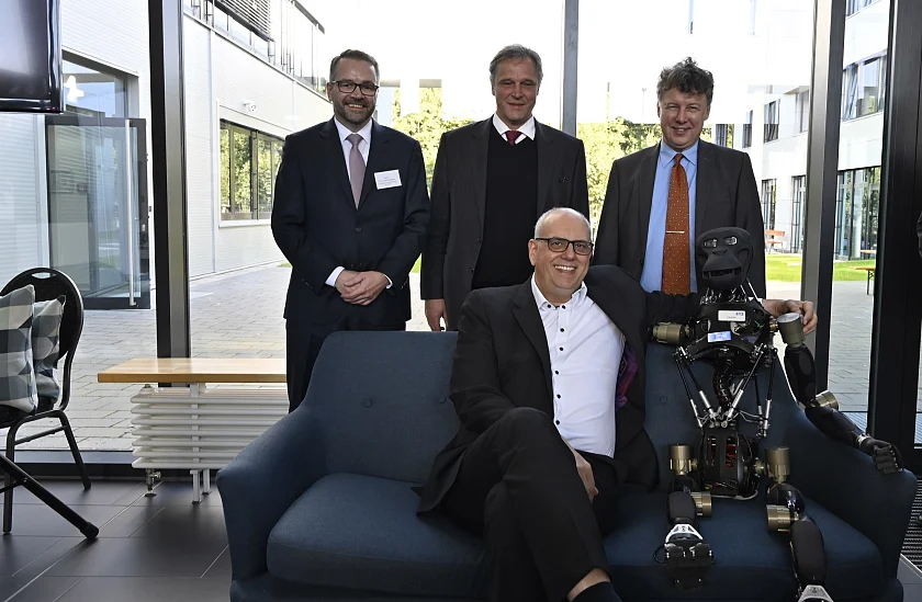 Kumpel Roboter im Arm: Bürgermeister Andreas Bovenschulte (Mitte) bei der Eröffnung des Erweiterungsbaus des DFKI in Bremen. Dabei (von links) Wissenschafts-Staatsrat Tim Cordßen-Ryglewski, Prof. Dr. Frank Kirchner (Geschäftsführender Direktort DFKI Bremen) und Prof. Dr. Rolf Drechsler (Leiter des Forschungsbereichs Cyber-Physical Systems und Professor für Rechnerarchitektur an der Universität Bremen). Foto: Senatspressestelle