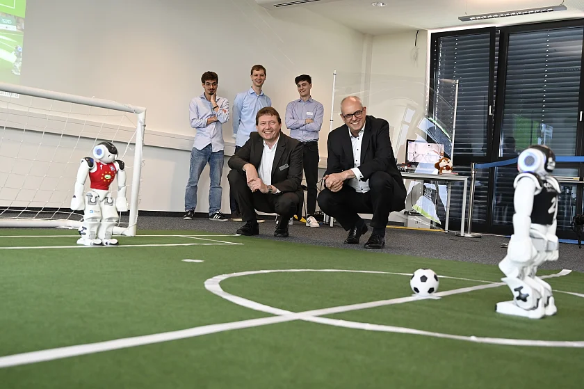 Die Bremer Fußball-Roboter sind nicht nur regelmäßig sehr erfolgreich bei internationalen Turnieren, sie können auch einfach begeistern. So auch Dr. Thomas Röfer (Teamleiter B-Human und Senior Researcher, links) und Bürgermeister Andreas Bovenschulte. Foto: Senatspressestelle