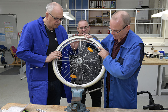 Sven Nollmann zeigt Bürgermeister Bovenschulte die Arbeitsschritte bei der Reparatur eines Rollstuhlreifens. Foto: Senatspressestelle