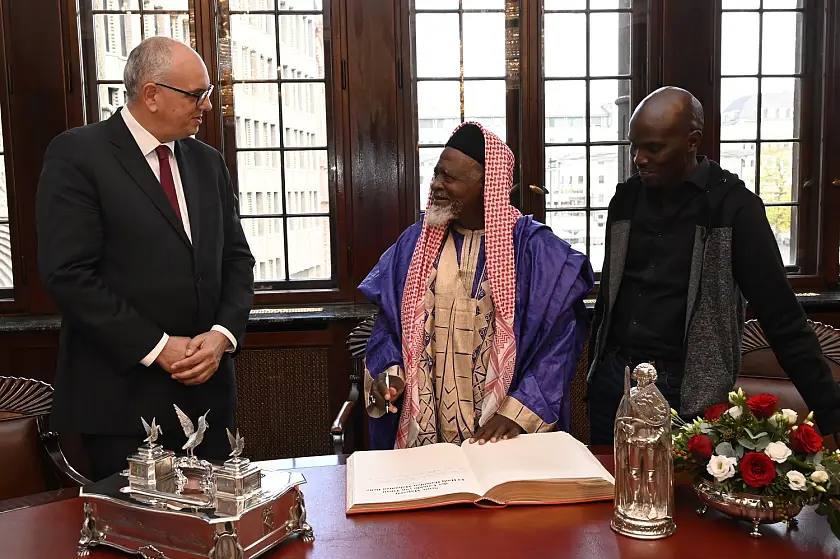 Der Lamido von Tibati (Mitte) hat sich bei seinem Besuch im Rathaus auch in das Goldene Buch eingetragen. Begrüßt wurde er von Bürgermeister Dr. Andreas Bovenschulte (links). Rechts im Bild Übersetzer Sanda Mazi. Foto: Senatspressestelle