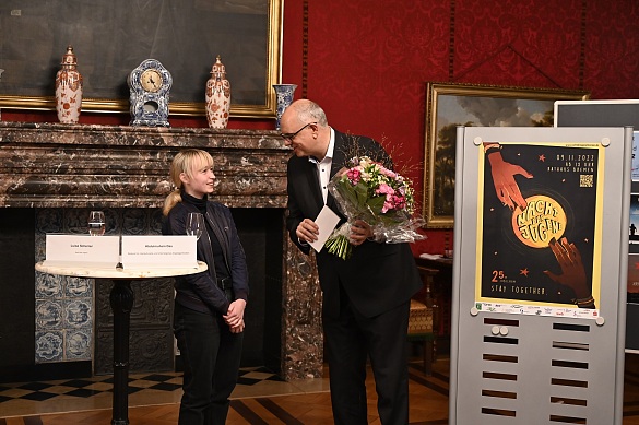 Pia Thurn hat mit ihrem Entwurf des Plakats zur Nacht der Jugend 2022 den Wettbewerb gewonnen. Bürgermeister Andreas Bovenschulte gratulierte ihr. Foto: Senatspressestelle