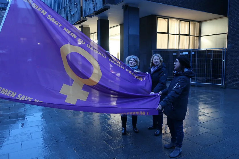 Hissen die Flagge Bremen sagt nein zu Gewalt gegen Frauen bei Sonnenaufgang (von links): Landesfrauenbeauftragte Bettina Wilhelm, Bürgerschafts-Vizepräsidentin Antje Grotheer und Gönül Bredehorst (MdBB). Foto: ZGF