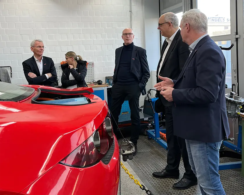 In der Kraftfahrzeugtechnik-Werkstatt zeigen Jens Rigterink, Geschäftsführer der Handwerk gGmbH), Bürgermeister Andreas Bovenschulte, der Präses der Handwerkskammer Bremen, Thomas Kurzke, und Hauptgeschäftsführer Andreas Meyer. Foto: Senatspressestelle