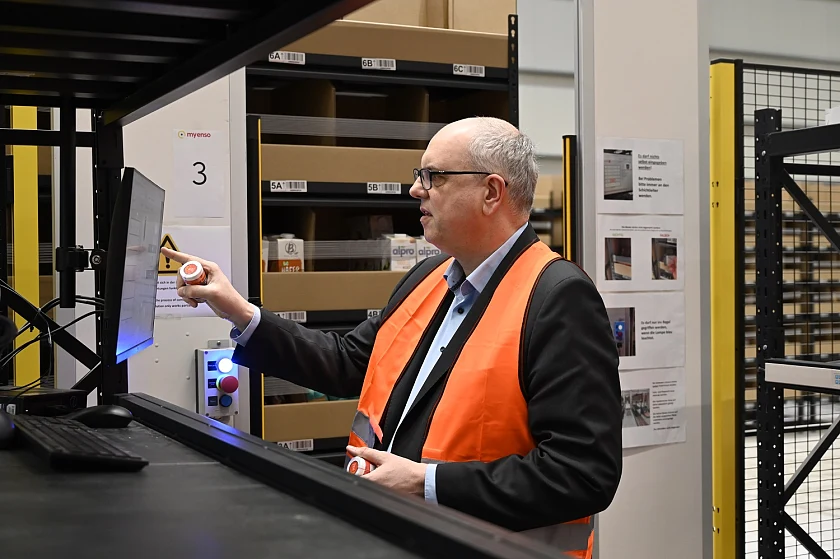Bürgermeister Andreas Bovenschulte packt im Hochregallager von myEnso mit an. Foto: Senatspressestelle