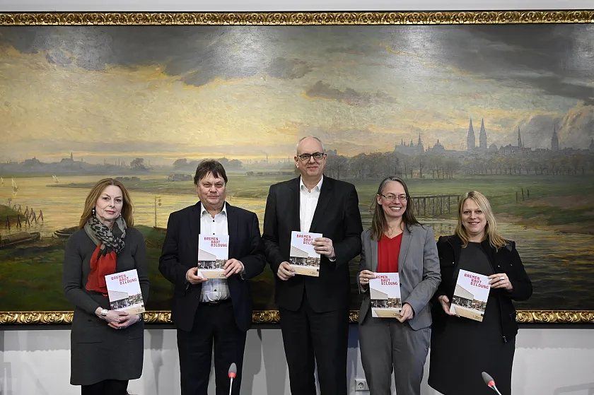 Geschäftsführerin von Immobilien Bremen, Susanne Kirchmann, Finanzsenator Dietmar Strehl, Bürgermeister Andreas Bovenschulte, Kinder- und Bildungssenatorin Sascha Karolin Aulepp und Bausenatorin Maike Schaefer präsentieren das Ergebnis der ressortübergreifenden Zusammenarbeit. Foto: Senatspressestelle