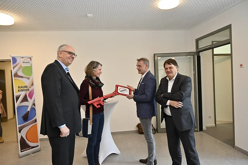 Der Schlüssel geht vom Bauherrn an die Nutzerin (von links): Bürgermeister Andreas Bovenschulte, Barbara Köberlein (Vorstand QUIRL Kinderhäuser e.V.), Brebau-Vorstand Bernd Botzenhardt und Finanzsenator Dietmar Strehl. Foto: Senatspressestelle