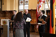Innensenator Ulrich Mäurer überreicht den neu eingebürgerten Bremerinnen und Bremern ihre Urkunde. Foto: Senatspressestelle