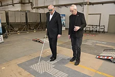 An der Seite von Prof. Dr. Carsten-W. Müller von der Hochschule Bremen erfuhr Bovenschulte, was es heißt, sich mit einem Blindenstock über Markierungen auf dem Boden zu orientieren. Foto: Senatspressestelle