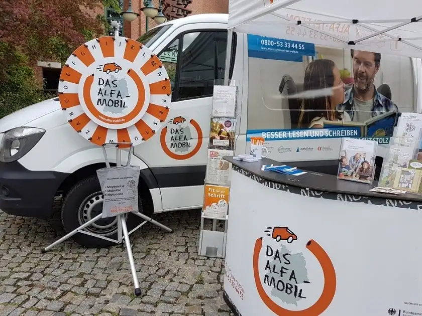 Aufsuchende Beratung: Am ALFA-Mobil-Stand werden in der kommenden Woche an drei Standorten in Bremen interessierte Menschen und Betroffene mit Lese- und Schreibschwierigkeiten informiert. Foto: BVAG