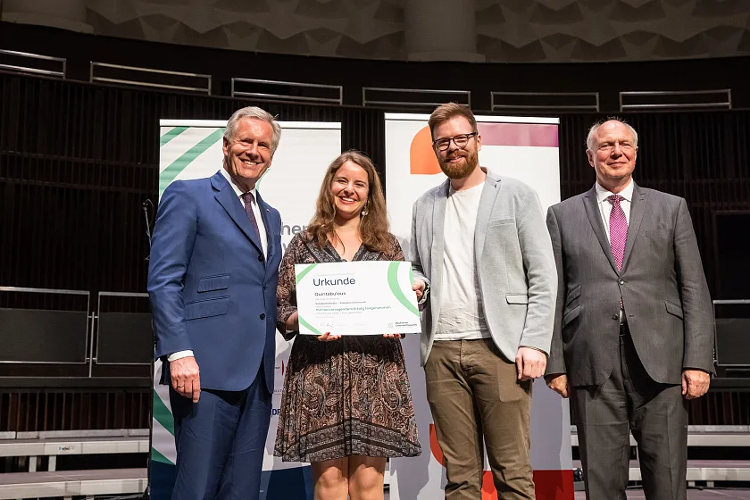Urkundenübergabe im Rahmen des Preisträgerkonzerts - Mitglieder von Quintabulous mit Bundespräsident a.D. Christian Wulff (links, Präsident des Deutschen Chorverbandes) sowie Prof. Martin Maria Krüger (rechts, Präsident des Deutschen Musikrates). Von Quintabulous zu sehen sind: Ronja Most (Alt) und Christian Bratschke (Tenor). Foto: Helge Krückeberg / DCW / DMR