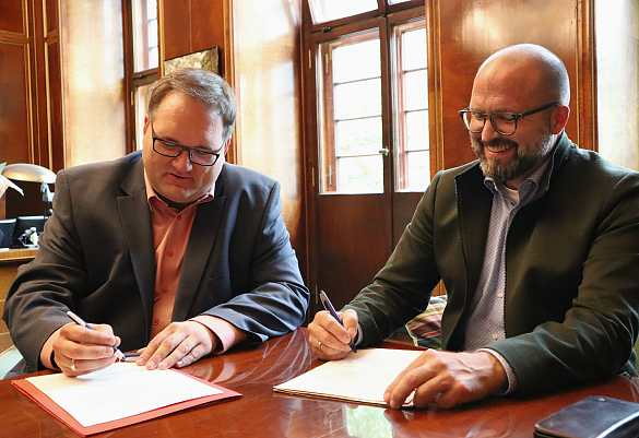 Finanzsenator Björn Fecker (links) und der Vorsitzende des Gesamtpersonalrats, Lars Hartwig, unterzeichnen die Dienstvereinbarung Ortsflexibles Arbeiten. Foto: Finanzressort