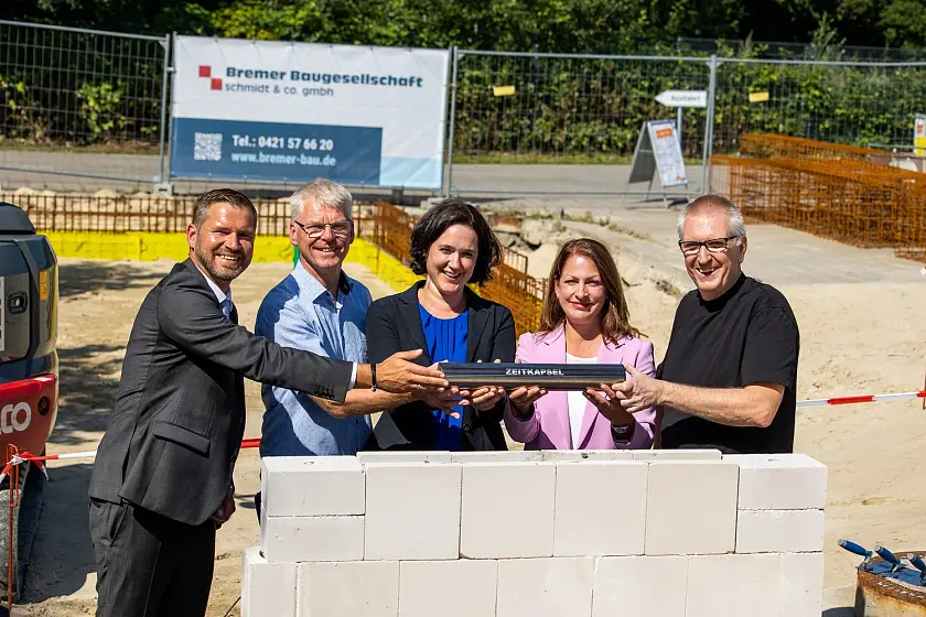 Versenkten gemeinsam die Zeitkapsel in den Grundstein des neuen Verwaltungsgebäudes der Recyclingstation in Blumenthal (von links): Oliver Fröhlich (Ortsamtsleiter Blumenthal), Thomas Wemhoff (Die Bremer Stadtreinigung, Abteilungsleiter für Deponie und Recycling-Stationen), Kathrin Moosdorf (Senatorin für Umwelt, Klima und Wissenschaft), Daniela Enslein (Vorständin der Bremer Stadtreinigung) und Burkard Bruns (Bruns+Hayungs Architekten GbR). Foto: DBS, Fotoetage/Tristan Vankann