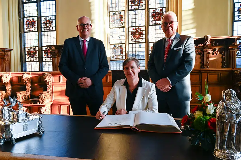 Eintrag in das Goldene Buch; Bürgermeister Andreas Bovenschulte (li.), Botschafterin Alda Vanaga und Honorarkonsul Lutz Peper. Foto: Senatspressestelle