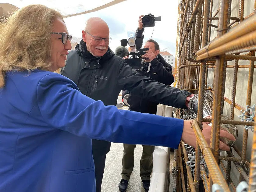 Bausenatorin Özlem Ünsal und Innensenator Ulrich Mäurer legen die Zeitkapsel in das Fundament des neuen Kommissariats. Foto: Bauressort 
