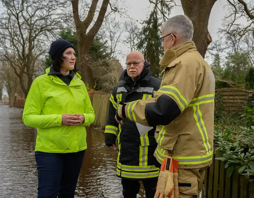 Umweltsenatorin Kathrin Moosdorf (links) und Innensenator Ulrich Mäurer (Mitte) lassen sich in Bremen-Borgfeld die aktuelle Hochwasserlage vom stellvertretenden Leiter der Feuerwehr Bremen, Michael Richartz, erläutern. Foto: Senatspressestelle