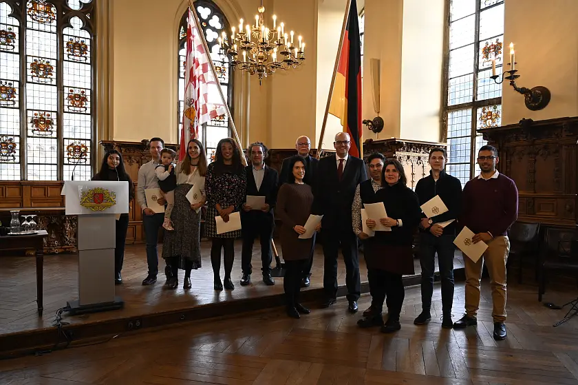 Bürgermeister Andreas Bovenschulte und Innensenator Ulrich Mäurer zusammen mit neu eingebürgerten Bremerinnen und Bremern. Foto: Senatspressestelle 