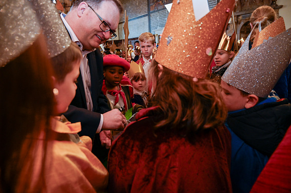 Bürgermeister Björn Fecker verteilt seine Spende an die Sternsingerinnen und –singer. Foto: Senatspressestelle