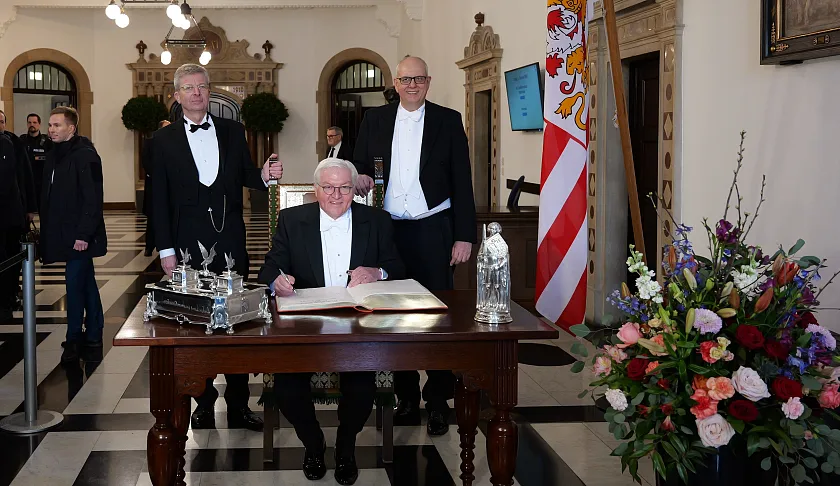 Bundespräsident Frank-Walter Steinmeier ist Ehrengast der Schaffermahlzeit. Er trug sich vor Beginn in das Goldene Buch ein, begleitet vom Verwaltenden Vorsteher des Haus Seefahrt Henry Lamotte (links) und Bürgermeister Andreas Bovenschulte.  Foto: Senatspressestelle