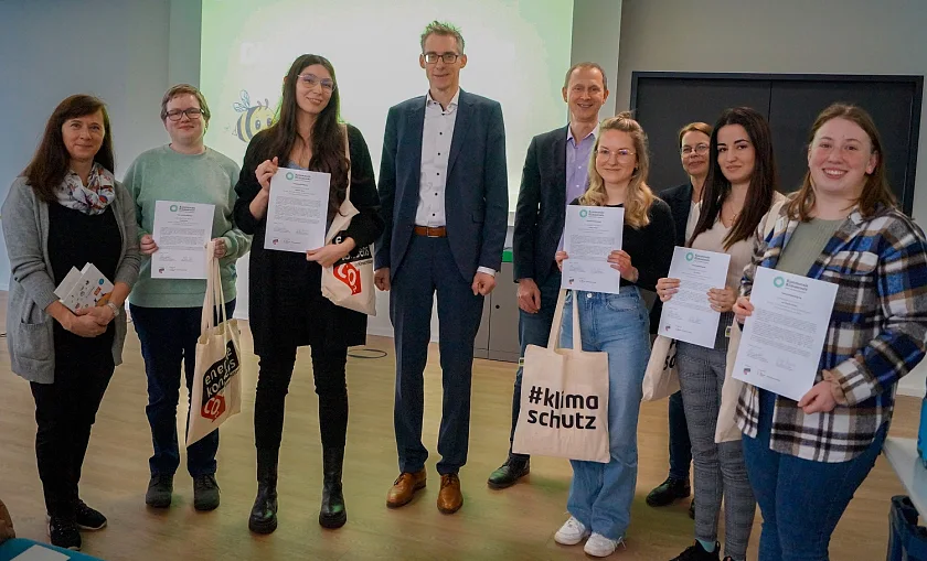 Auszubildende stellen Klimaprojekte vor: Die Arbeitsgruppe Klima Rallye (vorne) zusammen mit (v. l. n. r.) Staatsrat Martin Hagen, energiekonsens-Geschäftsführer Martin Grocholl, Katja Lessing, Direktorin der Verwaltungsschule und Hille Heumann-Klemm, Projektleiterin bei energiekonsens, bei der Abschlussveranstaltung im Projekt Kommunale Klimascouts. Foto: energiekonsens