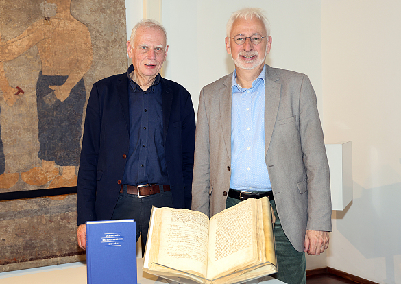 Dr. Ulrich Weidinger (links) und der Leiter des Staatsarchives Bremen, Prof. Dr. Konrad Elmshäuser, präsentieren das Ratsdenkelbuch von 1395. Foto: Kulturressort