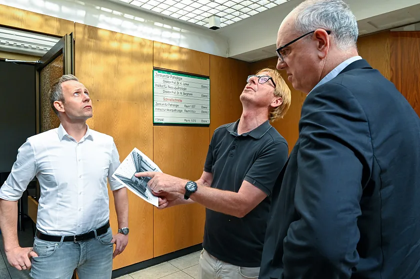 Projektentwickler Klaus Meier (Mitte) und Johannes Aderholz (li.) zeigten Bürgermeister Andreas Bovenschulte historische Aufnahmen der Alten Pathologie und erklärten, wie diese wiederhergerichtet werden soll. Foto: Senatspressestelle
