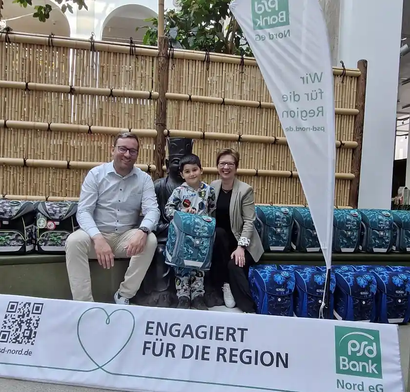 Gerüstet für den Schulanfang: Der künftige Erstklässler Muhammed mit Senatorin Claudia Schilling mit dem Leiter Omnikanalvertrieb der PSD-Bank-Nord, Dominik Schulte, im Überseemuseum. Foto: Sozialressort