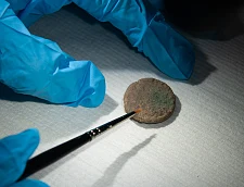 Die Scheibenfibel wird freigelegt und restauriert. Foto: Landesarchäologie Bremen