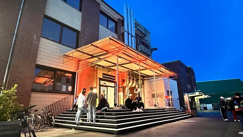 Abendstimmung vor dem Zentrum für Kunst mit Personen. Foto: Zentrum für Kunst