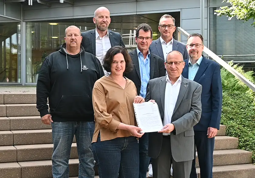 Senatorin Kathrin Moosdorf überbringt dem CEO Dr. Thomas Bünger die Genehmigung für das geplante klimaneutrale Bremer Stahlwerk (vordere Reihe). Mit dabei sind auch der Betriebsratsvorsitzende des Unternehmens Mike Böhlken, der Arbeitsdirektor Michael Hehemann, der Projektleiter Umweltschutz Bernd Walter und der Leiter Umweltschutz Norbert Schekelenski. Aus der Senatorischen Behörde war der Abteilungsleiter technischer Umweltschutz und Naturschutz Michael Bürger zugegen. Foto: Umweltressort