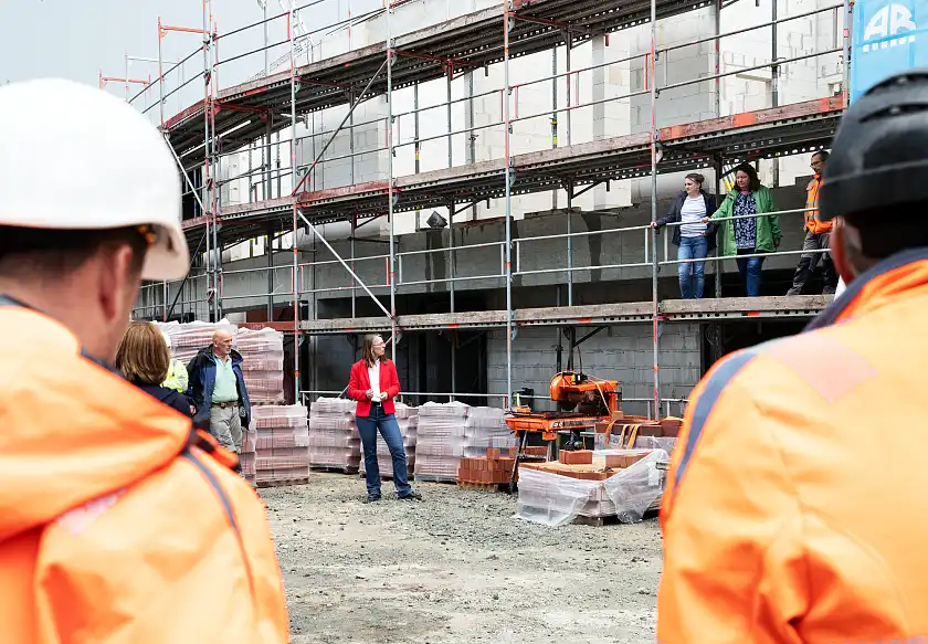 Senatorin Aulepp (Mitte) eröffnet das Rohbaufest gemeinsam mit den Kitaleitungen Susanne Brüning und Frau Katrin Pufke (auf dem Gerüst). Foto: Bildungsressort