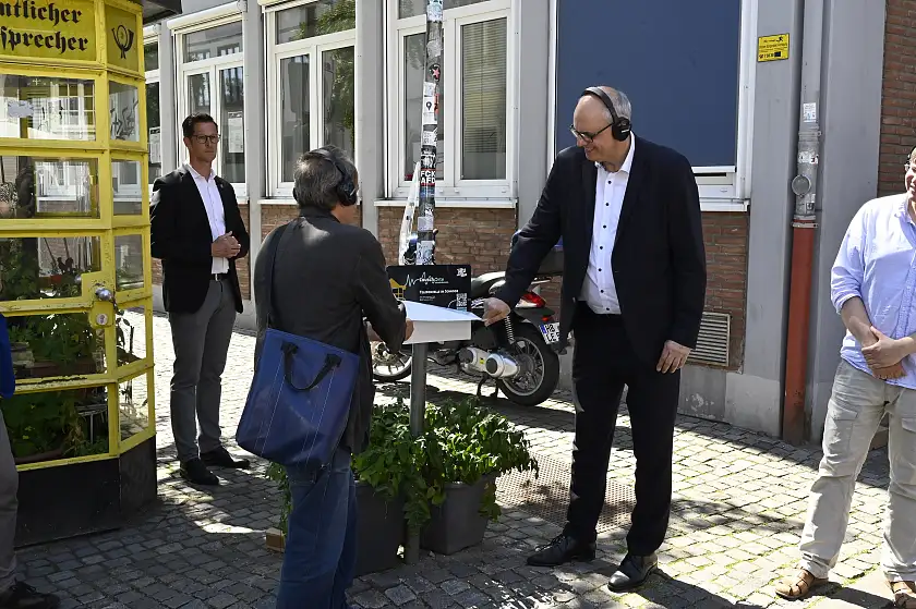 Bürgermeister Andreas Bovenschulte nimmt den neuen LauschOrt an der Telefonzelle im Schnoor in Betrieb. Foto: Senatspressestelle