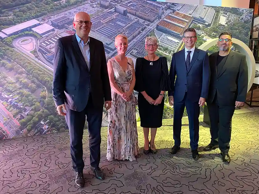 Vor einem Luftbild des Mercedes-Werkes Bremen (von links): Bürgermeister Andreas Bovenschulte, die beiden Jubilarrednerinnen Jessica San und Claudia Rickers aus der Karosseriefertigung, Werksleiter Michael Frieß und der stellvertretende Betriebsratsvorsitzende Serkan Gök. Foto: Mercedes-Benz