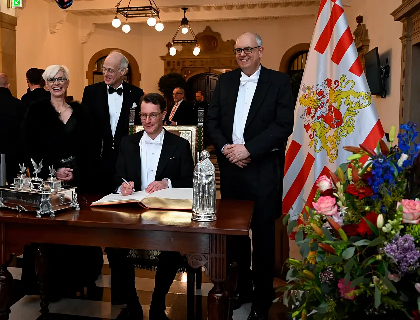 Ministerpräsident Hendrik Wüst trägt sich anlässlich der 481. Schaffermahlzeit in das Goldene Buch ein; mit im Bild: Bürgermeister Andreas Bovenschulte (re.), Prof. Dr.-Ing. Anke Kaysser-Pyzalla, Vorsitzende des Vortsands des Deutschen Zentrums für Luft- und Raumfahrt e.V. (li.) und der Verwaltende Vorsteher von Haus Seefahrt, Fritz A. Grobien.